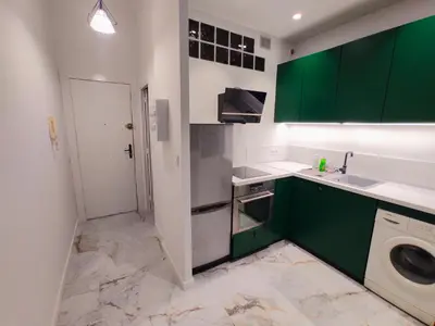 a kitchen with green cabinets and a washing machine at GARDEN LEVEL nearby beach in Nice