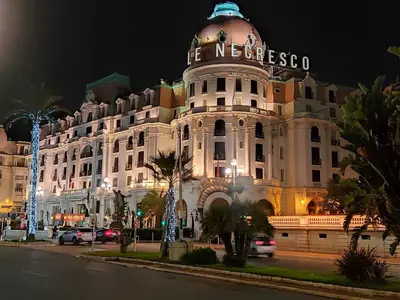 a building with a sign on top of it at night at GARDEN LEVEL nearby beach in Nice
