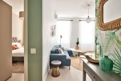 a bedroom with a blue chair and a bed and a mirror at Very nice 2p with all comfort, city center Ac/wifi in Nice