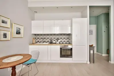 a kitchen with white cabinets and a wooden table at Very nice 2p with all comfort, city center Ac/wifi in Nice