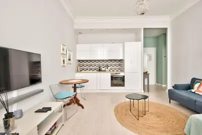 a living room with a blue couch and a kitchen at Very nice 2p with all comfort, city center Ac/wifi in Nice
