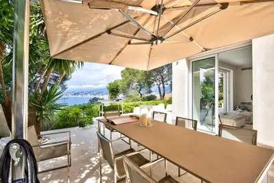 a patio with a table and chairs and an umbrella at Villa Mont Boron, vue mer exceptionnelle in Nice