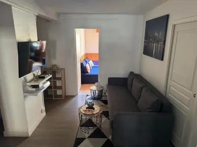 a living room with a couch and a television at 4 pièces à Nice - 20 min de la plage in Nice