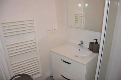 a white bathroom with a sink and a mirror at 4 pièces à Nice - 20 min de la plage in Nice
