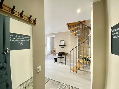a hallway with a spiral staircase and a dining room at Lovely & cozy duplex heart of Nice with bathtub! in Nice