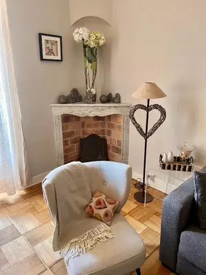 a living room with a chair and a fireplace at Magnifique 2 pièces de 65m2 -quartier des Musiciens in Nice