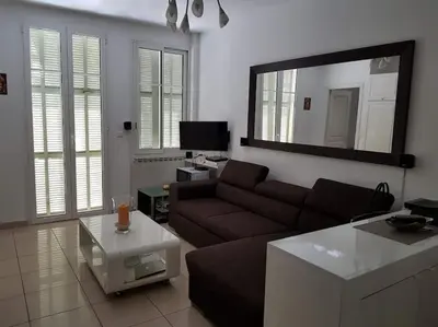 a living room with a couch and a table at Nice & Les Cypres in Nice