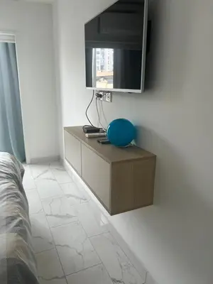 a bedroom with a tv on a white wall at Le Grand Bleu in Nice
