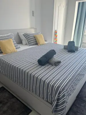 a large bed with blue and white sheets and pillows at Le Grand Bleu in Nice