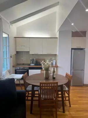 a kitchen with a table and chairs and a kitchen with a refrigerator at Le Michelangelo - Place Masséna in Nice