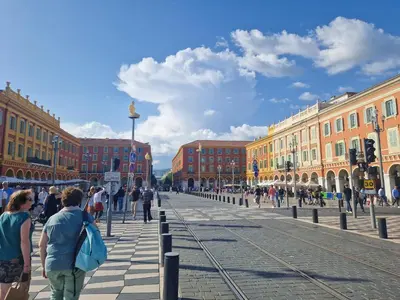 a group of people walking on a city street at Le Michelangelo - Place Masséna in Nice