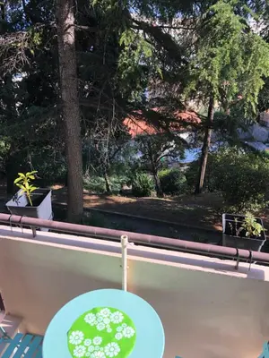 a table on a balcony with a view of trees at Appart Nice Marguerite in Nice