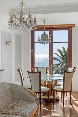 a dining room with a table and chairs and a chandelier at Luxury apartment with sea view on the first line Promenade des Anglais in Nice