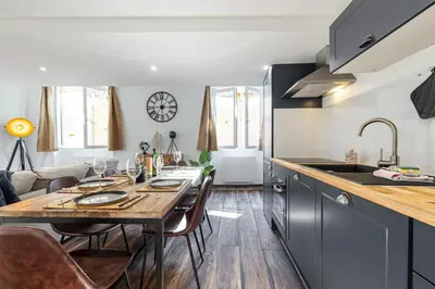 a kitchen and living room with a wooden table and a dining room at Spacious 2 Bdr Old Town Heart in Nice