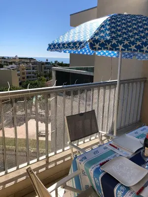 a table and an umbrella on a balcony at Charmant studio à Cros de Cagnes in Cagnes-sur-Mer