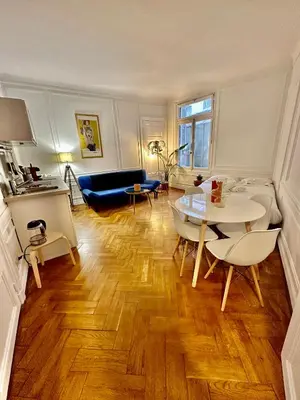 a living room with a table and a couch at Negresco Residence Apartment with AC Promenade des Anglais in Nice