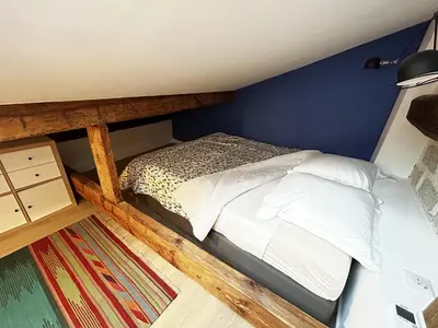 a bed in a room with a blue wall at Nice Chateau Duplex Menica vue sur le vieux Nice in Nice