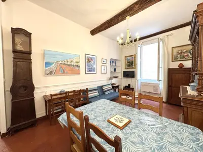 a dining room with a table and a clock on the wall at ApartHotel Riviera - BARILLERIE 3 - Vieille Ville 50m de la plage- 4 pieces - AC in Nice
