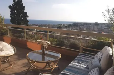 a balcony with a table and a view of the ocean at Appartement Nice CENTRE vue Mer avec piscine pour FAMILLE, couple d'amis pas de groupes de jeunes autorisés in Nice