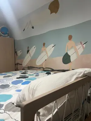 a bedroom with a mural of surfers on a wall at Appartement Nice CENTRE vue Mer avec piscine pour FAMILLE, couple d'amis pas de groupes de jeunes autorisés in Nice