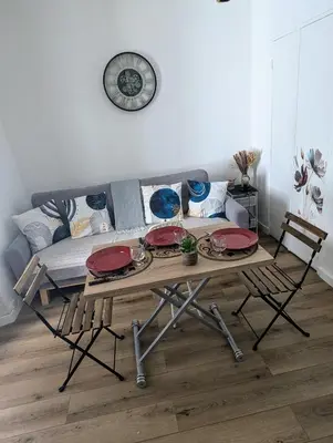 a living room with a table and a couch at Appartement cosy proche du port in Nice
