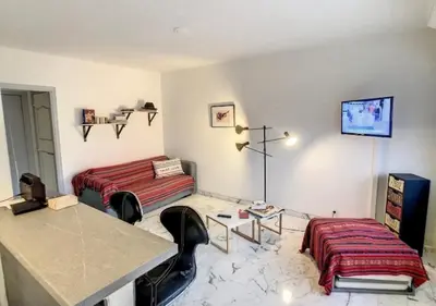 a room with two beds and a table and chairs at Superbe Studio tout équipé/Proche mer et commodité in Saint-Laurent-du-Var