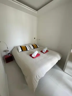 a white bedroom with a bed with two towels on it at T2 Carré D'Or in Nice
