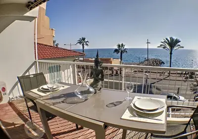 a table on a balcony with a view of the ocean at Charmant 2 pièces FACE à la MER- Cagnes sur Mer in Cagnes-sur-Mer