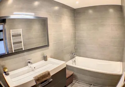 a bathroom with a tub and a large mirror at Charmant 2 pièces FACE à la MER- Cagnes sur Mer in Cagnes-sur-Mer