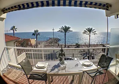 a table on a balcony with a view of the ocean at Charmant 2 pièces FACE à la MER- Cagnes sur Mer in Cagnes-sur-Mer