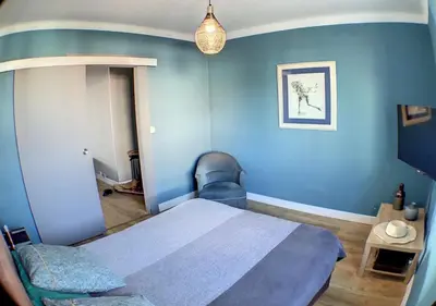 a blue room with a bed and a blue wall at Charmant 2 pièces FACE à la MER- Cagnes sur Mer in Cagnes-sur-Mer