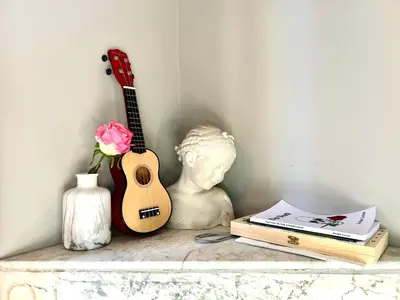 a statue and a guitar on a shelf with a bust at Lovely & sunny loft heart of Nice with A/C! in Nice