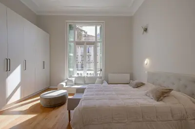 a white bedroom with a large bed and a couch at Maison Bianchi - Clemenceau in Nice