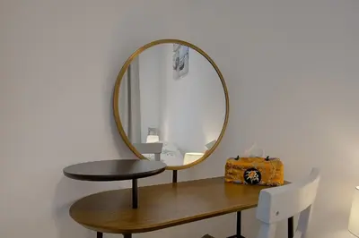 a round mirror on a table with a stool at Maison Bianchi - Saint Philippe in Nice