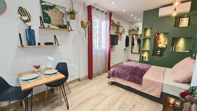 a bedroom with a bed and a table and chairs at Studio de charme climatisé Gare Riquier in Nice