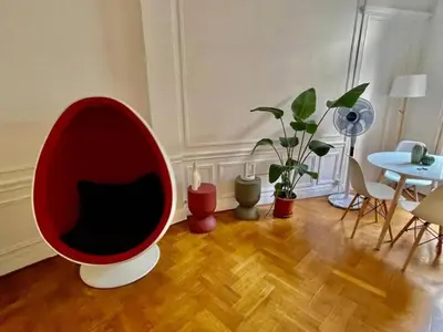 a living room with a red chair and a table at A Luxurious Apartment with AC on Promenade des Anglais in Nice