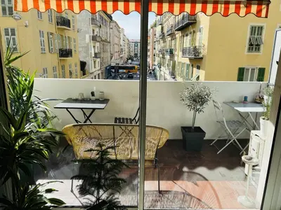 a balcony with a table and an umbrella at John Homestay Room in Nice in Nice