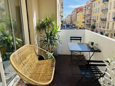 a balcony with a table and chairs on a balcony at John Homestay Room in Nice in Nice