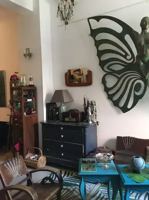 a living room with a table and a painting on the wall at LOFT D ARTISTES AVEC PATIO AU PORT DE NICE in Nice