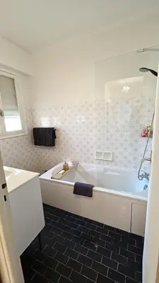 a white bathroom with a tub and a sink at Orangers Apartment in Nice