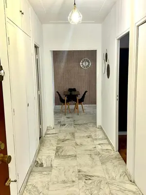 a hallway with a marble floor and a table at Orangers Apartment in Nice
