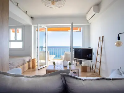 a living room with a couch and a tv at Apartment L'Angelina-2 by Interhome in Cagnes-sur-Mer