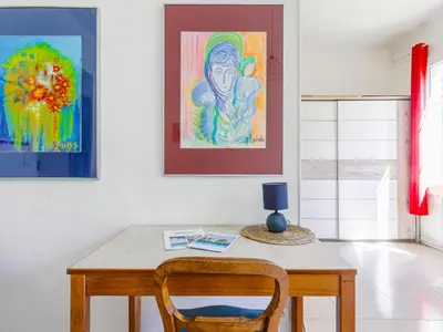 a table with a chair and a painting on the wall at Apartment Hérold-2 by Interhome in Nice