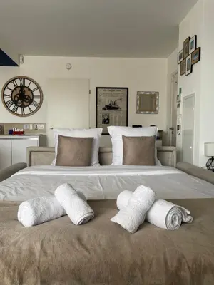 a large white bed with three pillows on it at Q&R Renting - Appartement luxueux et Suites design- Parking AC Mer in Nice