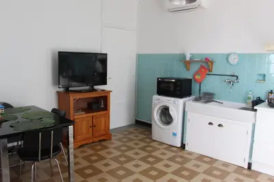 a kitchen with a washing machine and a tv at 2 pièces calme et fonctionnel in Cagnes-sur-Mer