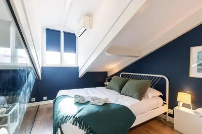 a bedroom with a bed with blue walls and windows at MY CASA - DEROULEDE - Superb Studio Suite w AC Downtown in Nice