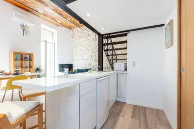 a kitchen with white cabinets and a wooden floor at MY CASA - GUBERNATIS - Beautiful Duplex with terrace in Nice