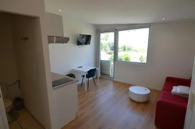 a living room with a red couch and a window at STUDIO CASSIN - next to tramway line 2 near airport in Nice