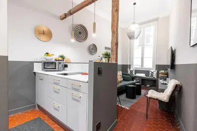a kitchen with white cabinets and a living room at MY CASA - LA CROIX - Old Town Modern apartment - 2 bedrooms in Nice