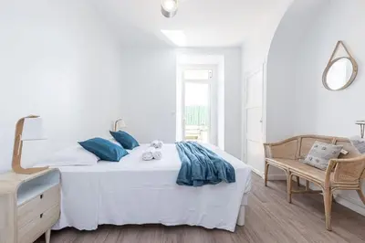a white bedroom with a bed and a chair at MY CASA - PONCHETTES - Independent House Promenade Des Anglais in Nice